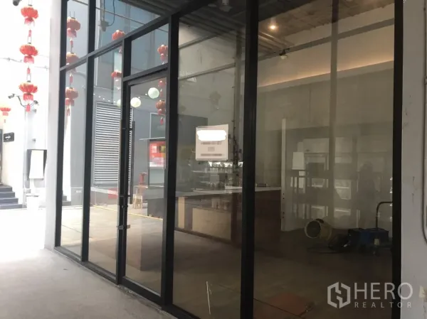 Retail Space for rent in Khlong Toei, Bangkok - Glass-front shop with full-height windows and entrance door facing a covered walkway.
