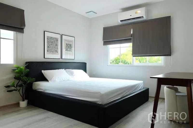 บ้าน ให้เช่าในBang Phli, Samut Prakan - ห้องนอนสว่าง มีเตียงคู่ แอร์ หน้าต่างสองด้าน และต้นไม้กระถาง