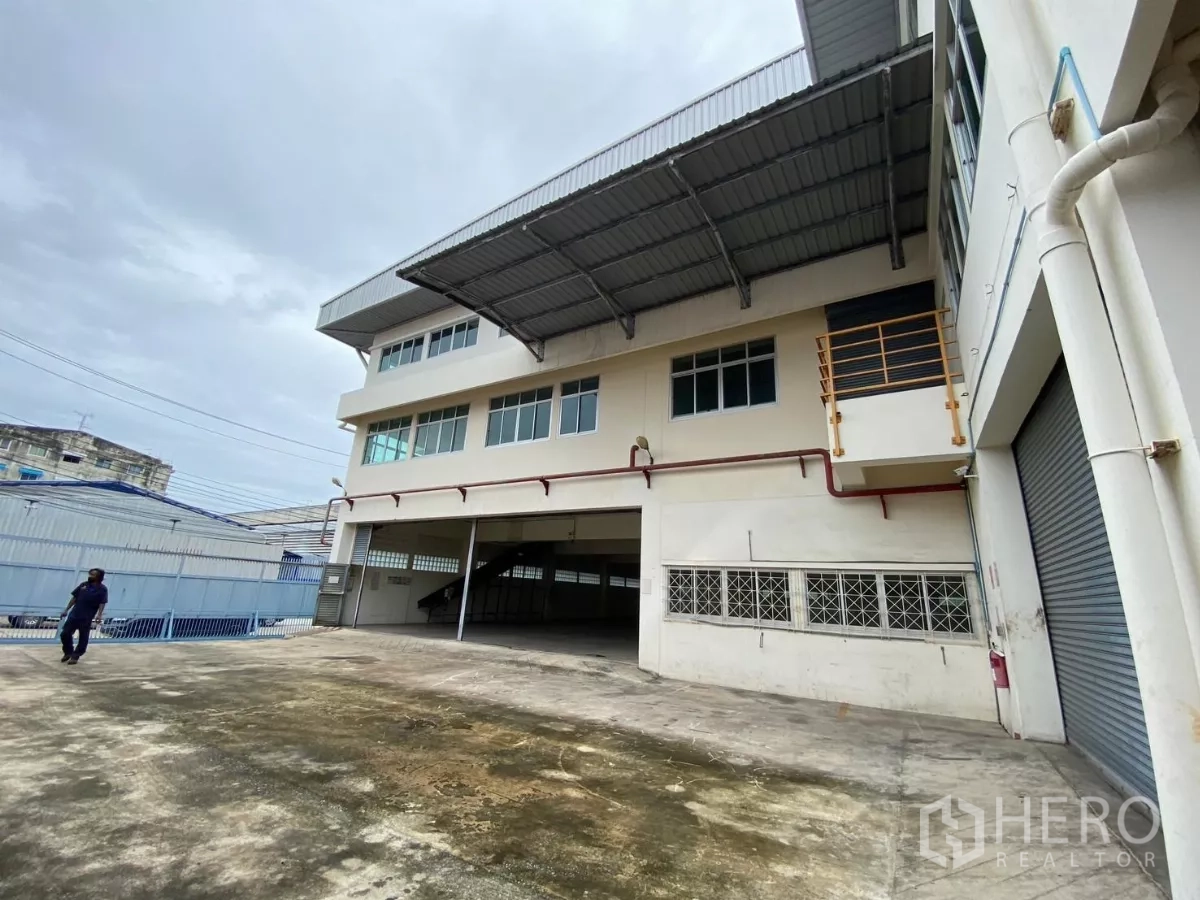 Factory for rent in Khlong Toei, Bangkok - Factory exterior with multiple roller shutters and a canopy over the loading area.