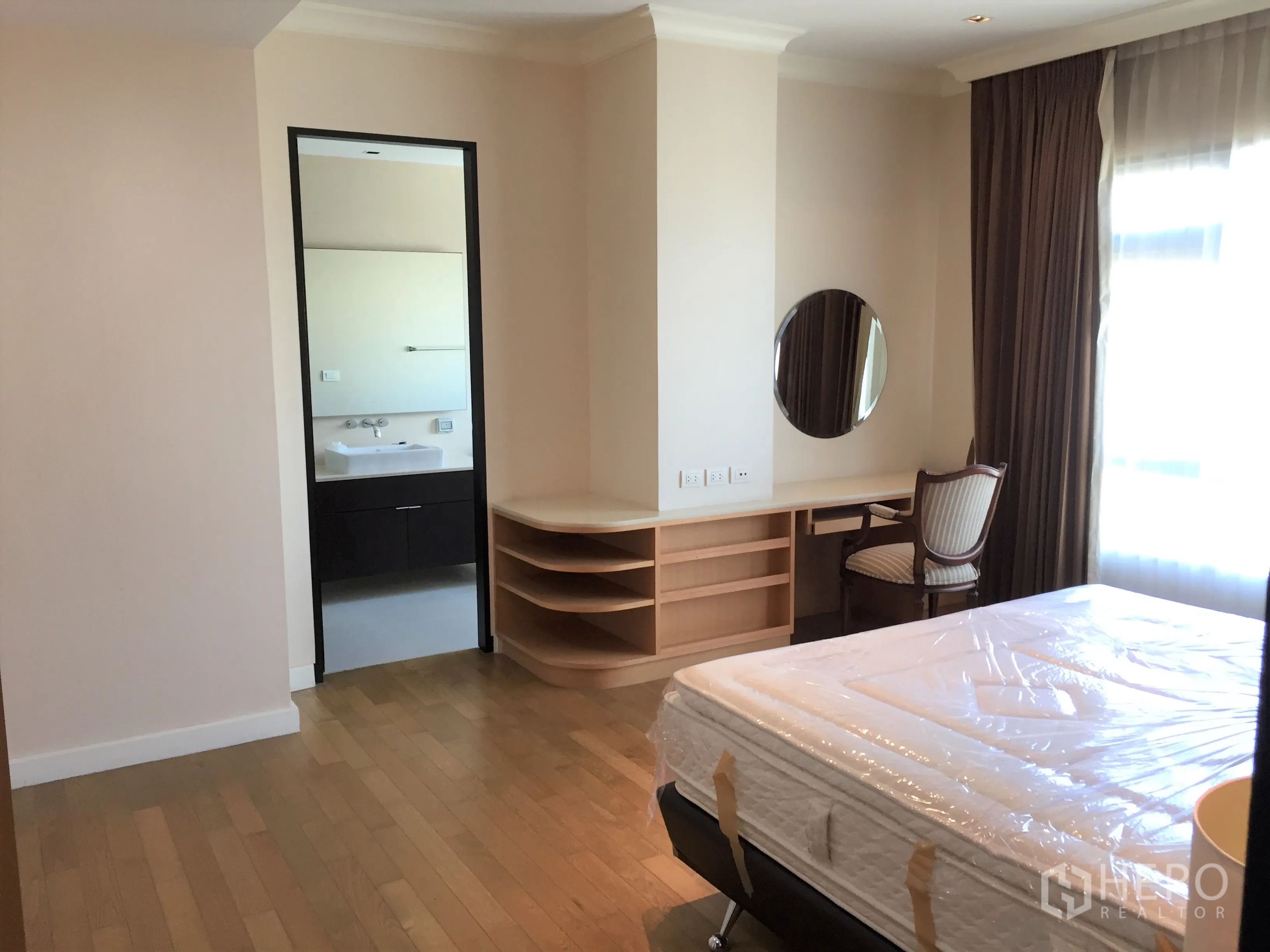 公寓 出租在Watthana, Bangkok - 卧室配大窗与梳妆台，并有门通往套内卫生间。
