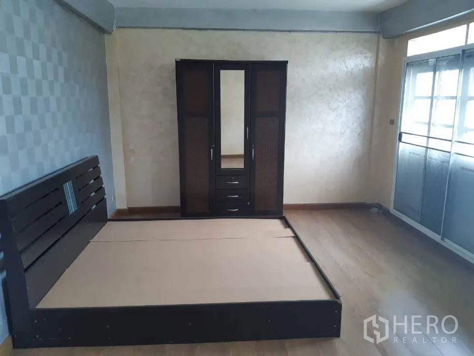 联排别墅 出租在Khlong Toei, Bangkok - 卧室配深色木质床架、衣柜与仿木地板。