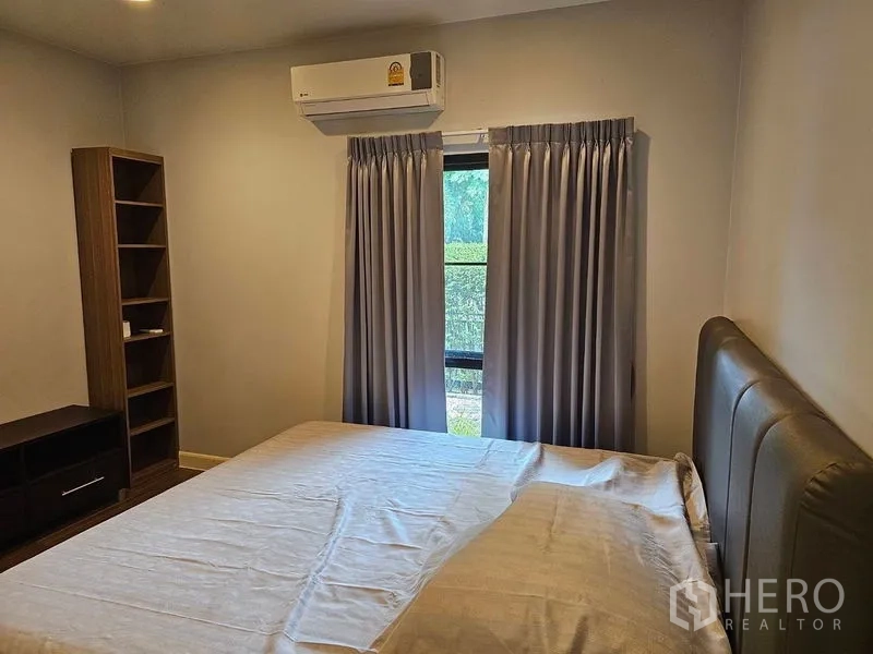 Detached House for rent or sale in Lam Luk Ka, Pathum Thani - Cozy bedroom with bed, shelving unit and air conditioner