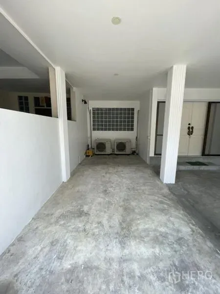 联排别墅 出租在Phra Khanong, Bangkok - 覆盖式车棚，水泥地面，带空调外机。