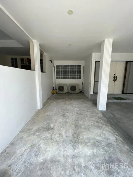 联排别墅 出租在Phra Khanong, Bangkok - 覆盖式车棚，水泥地面，带空调外机。