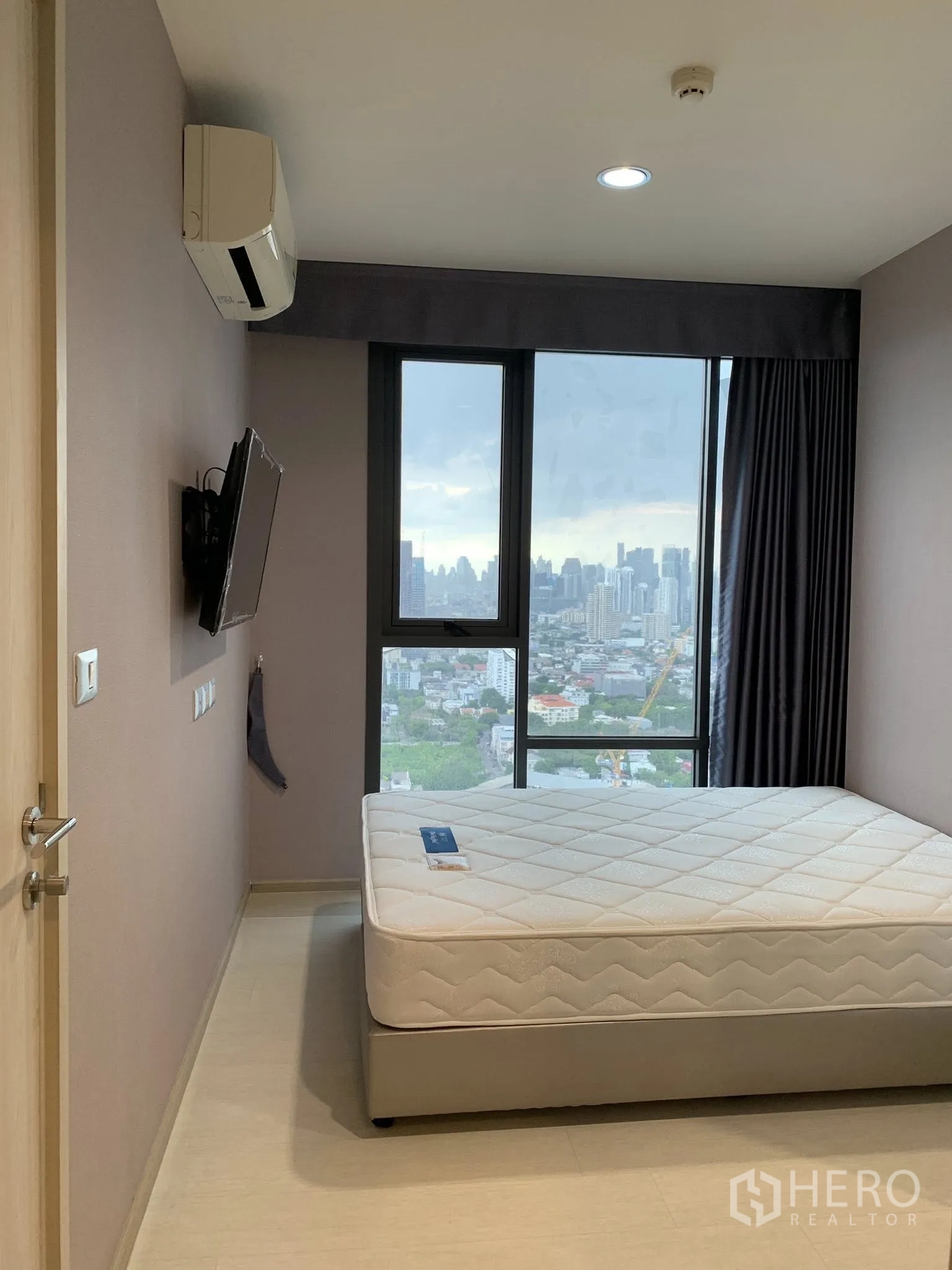 คอนโด for rent in Khlong Toei, Bangkok - ห้องนอนมีเตียง ทีวีติดผนัง เครื่องปรับอากาศ และหน้าต่างมองเห็นวิวเมือง