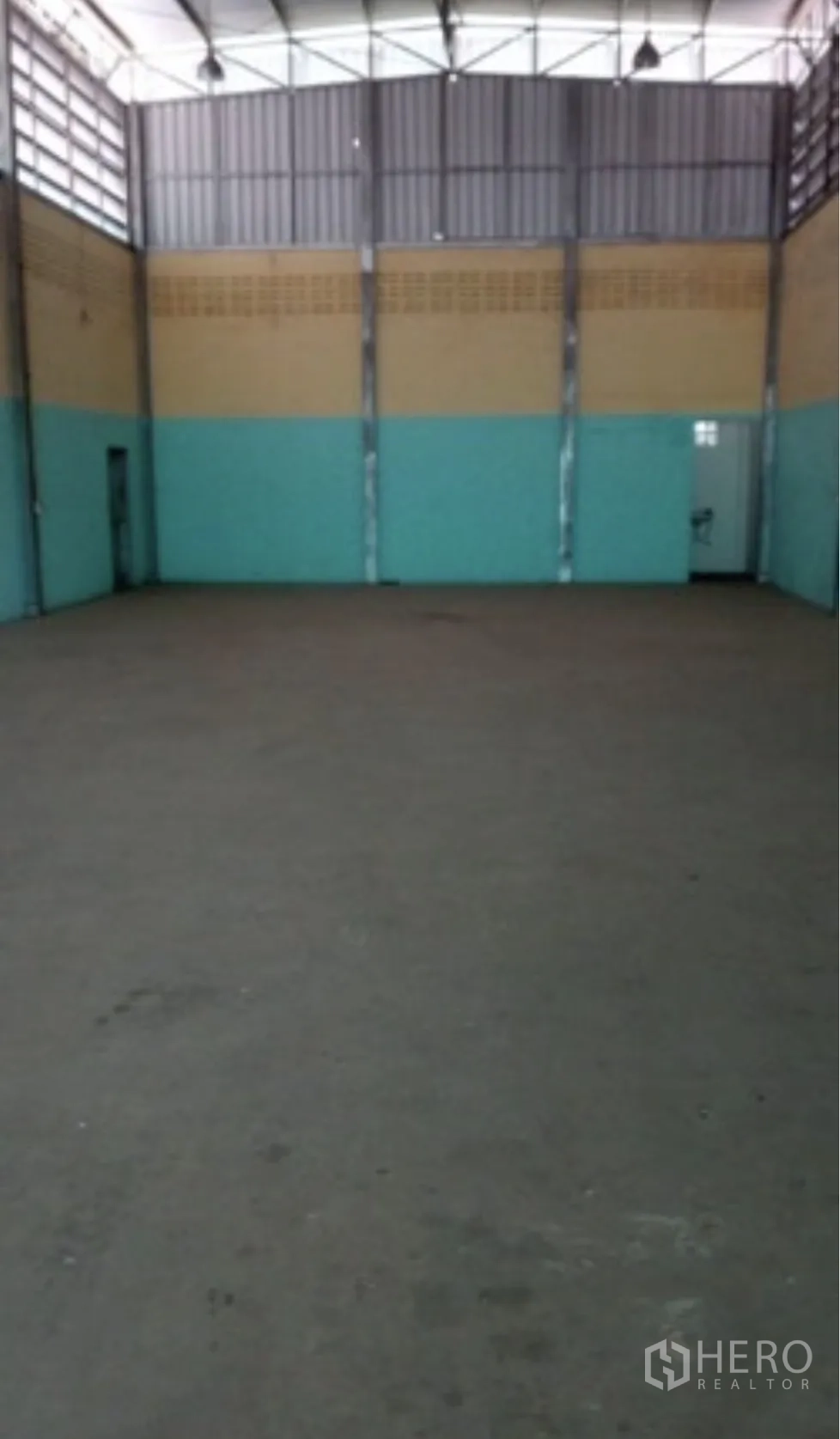 Warehouse for rent in Pak Kret, Nonthaburi - Open warehouse hall with high ceiling, steel trusses and a concrete floor.