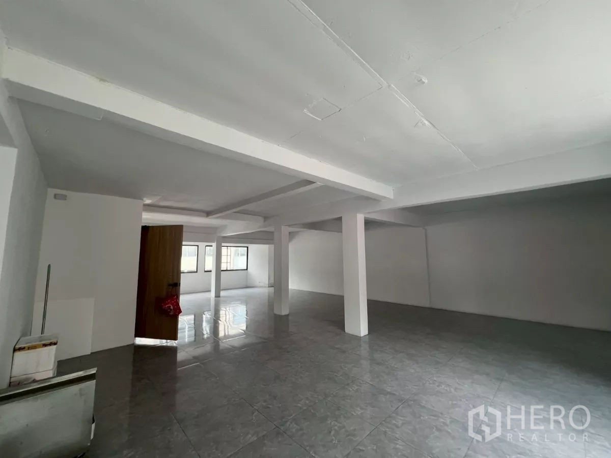Retail Space for rent in Pathum Wan, Bangkok - Open-plan space with central columns and a wooden door.