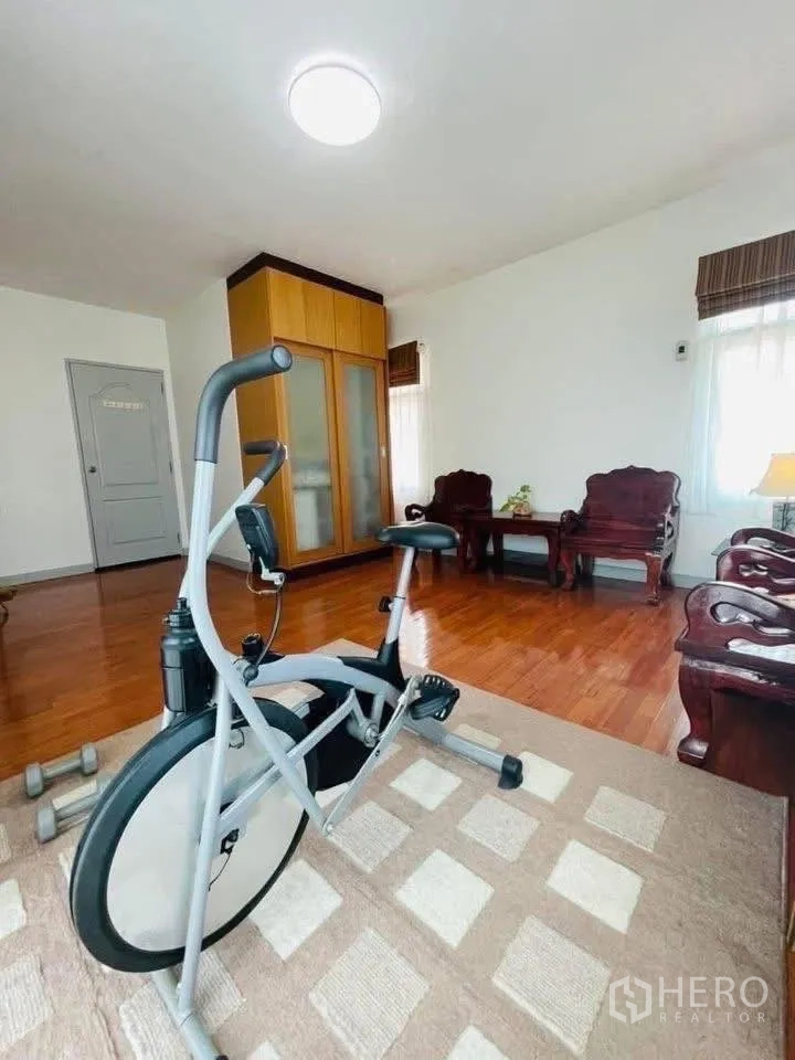 Detached House for rent or sale in Lam Luk Ka, Pathum Thani - Multipurpose room with exercise bike, wardrobe and seating set on carpet.