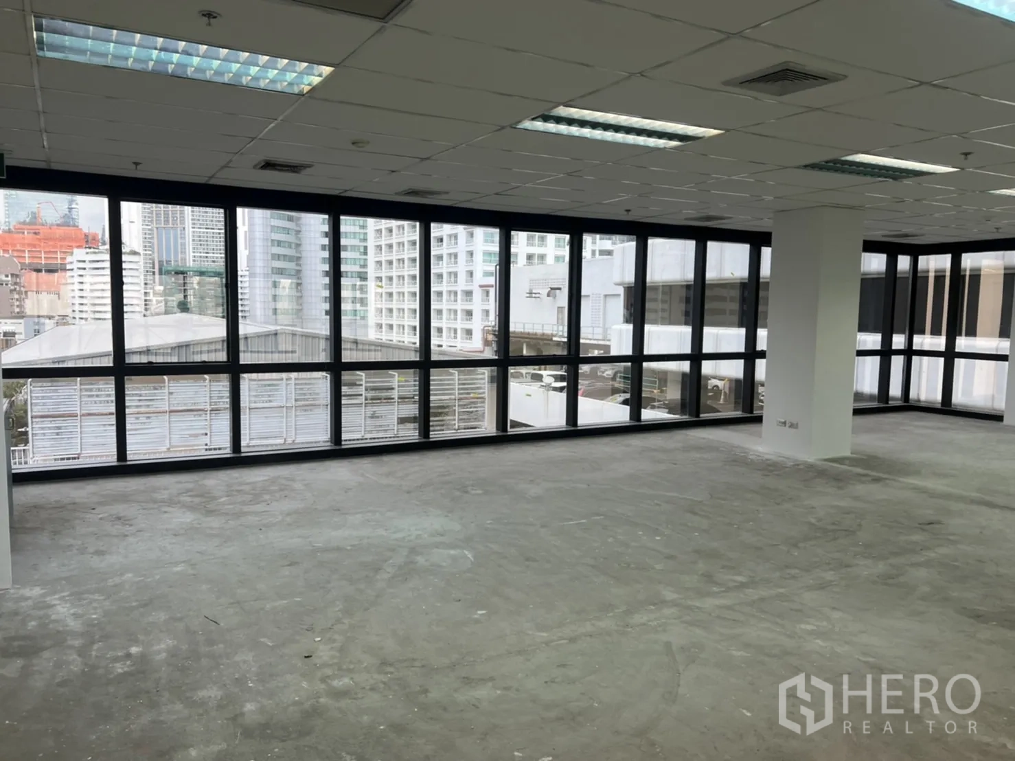 Office Space for rent in Watthana, Bangkok - Open office area with L-shaped windows overlooking adjacent buildings in the CBD.
