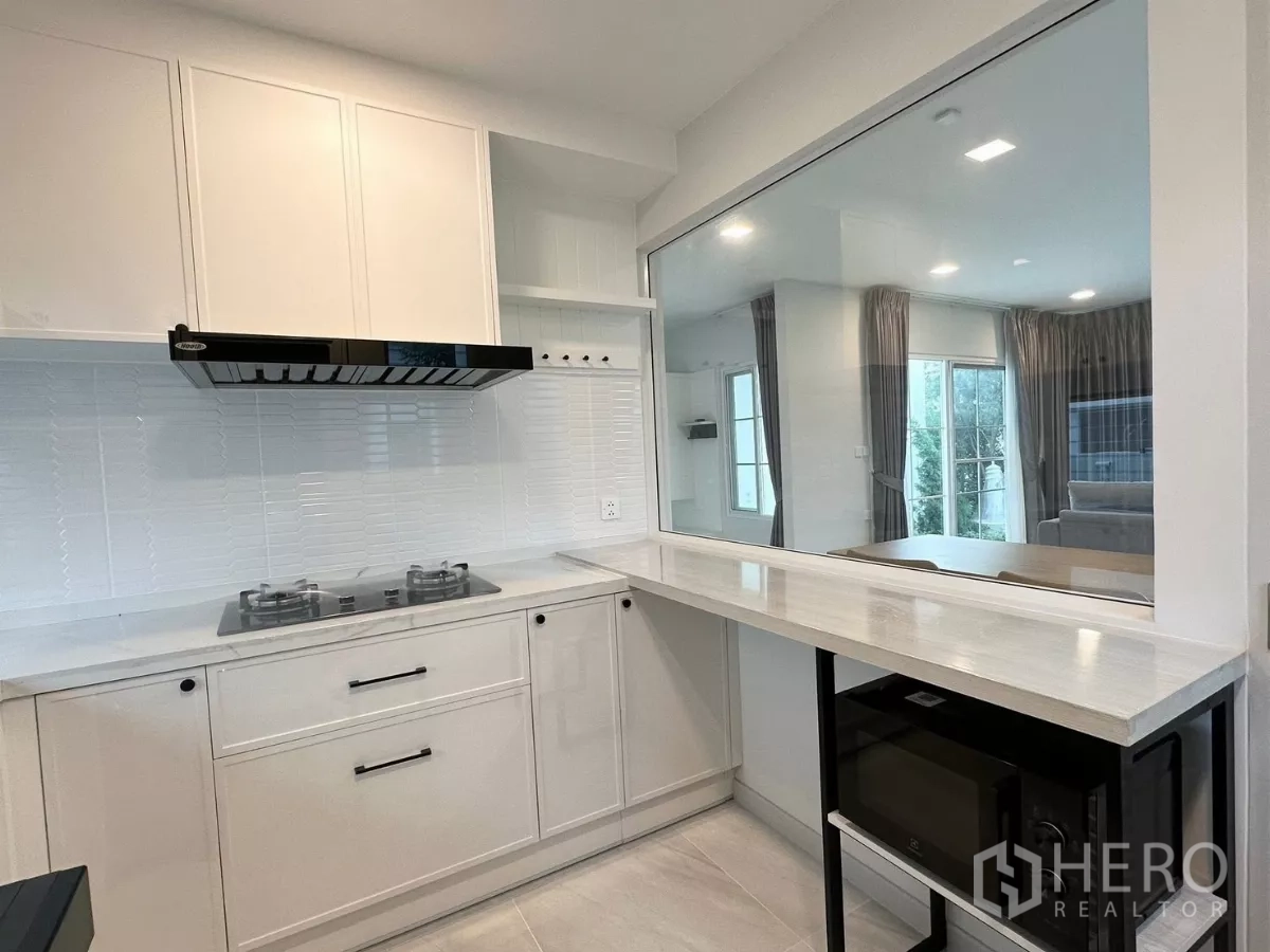 Detached House for rent in Bang Phli, Samut Prakan - Top-down view of a work desk by large windows with an indoor plant.