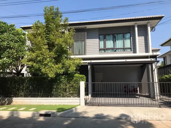 独立式住宅 出租在Bang Phli, Samut Prakan - 现代两层独栋住宅，带大门车道、遮棚车位与绿篱花园。