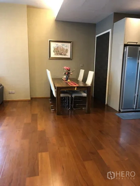 公寓 出租或出售在Watthana, Bangkok - 餐区木地板，旁边是不锈钢对开门冰箱。
