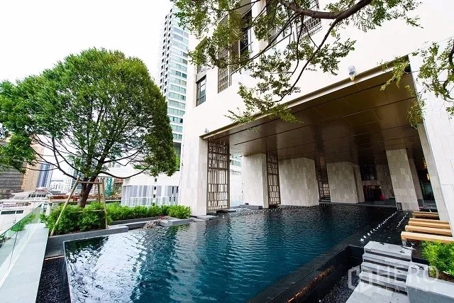 公寓 出租或出售在Watthana, Bangkok - 曼谷高端公寓的室外泳池，绿树环绕并可眺望城市天际线。