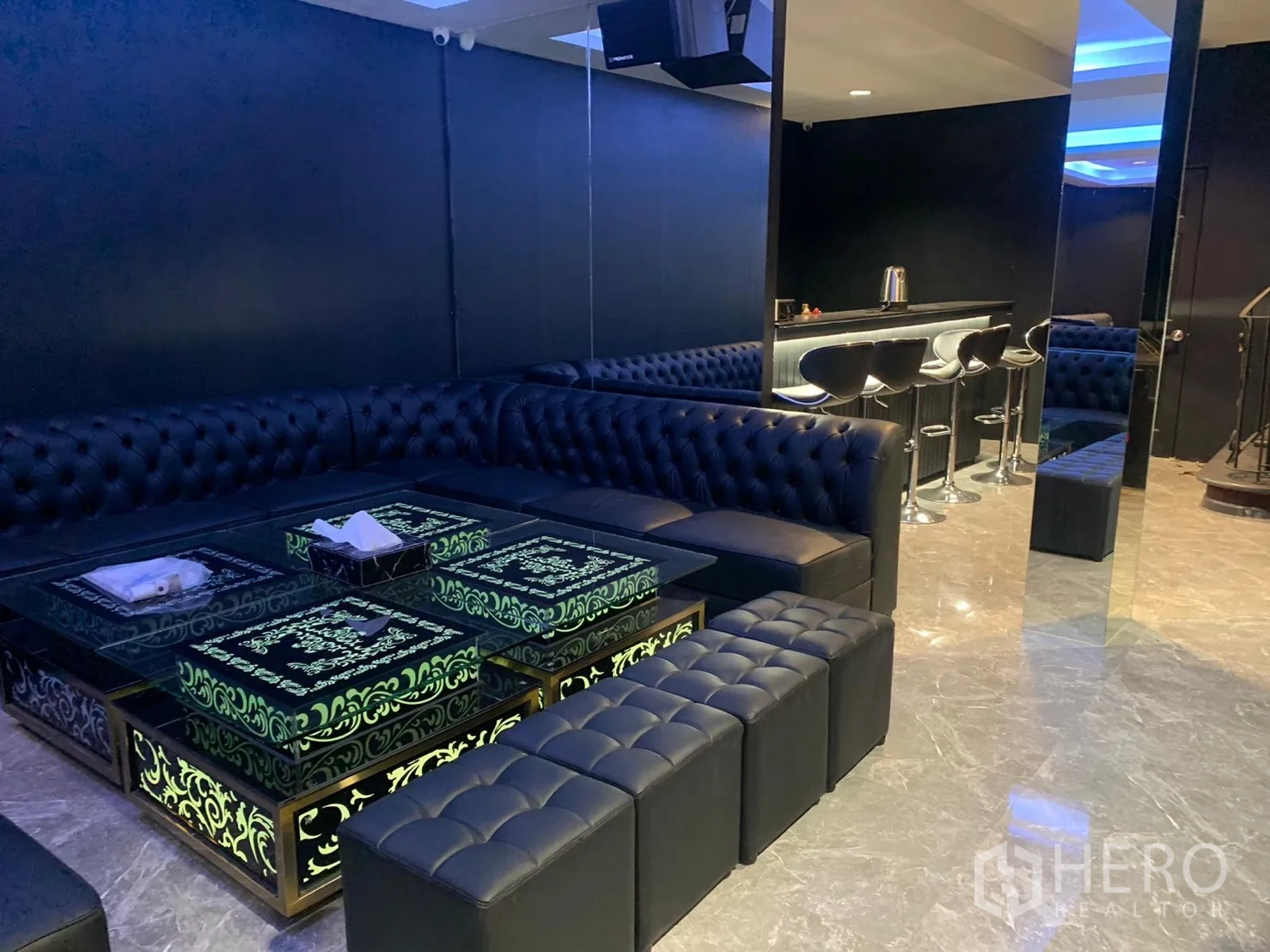 店屋 出租在Bangkok - 休息区，切斯特菲尔德沙发与发光图案玻璃茶几，旁有吧台。