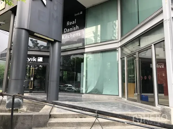 零售空间 出租在Watthana, Bangkok - 转角入口的玻璃展厅，双扇玻璃门与宽台阶，临街展示窗。