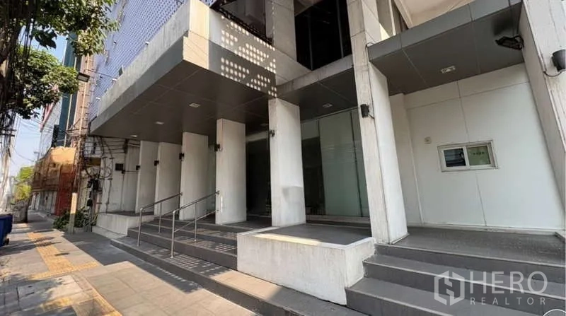 Standalone for rent in Khlong Toei, Bangkok - Modern standalone building entrance with glass facade, steps and ramp in Khlong Toei.