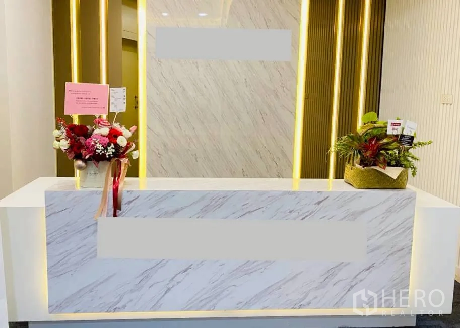 办公室 for rent in Sathon, Bangkok - 大理石前台配暖色灯带与花艺摆设。