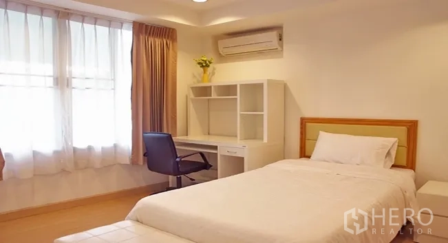 Apartment for rent in Khlong Toei, Bangkok - Second bedroom with single bed, study desk, shelving and wall-mounted air conditioner