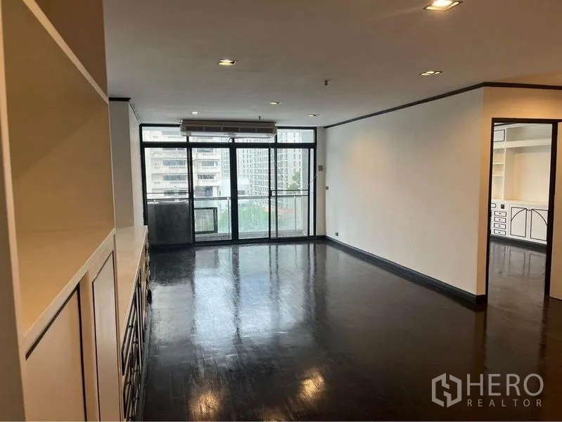 Condominium for rent or sale in Watthana, Bangkok - Wide living space with balcony access and separate bedroom entrance.