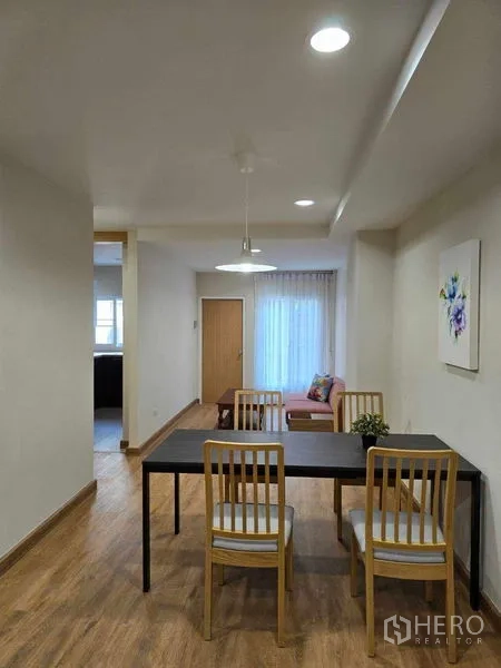 联排别墅 出租在Bang Na, Bangkok - 餐区配四人餐桌，吊灯与轻薄窗帘。