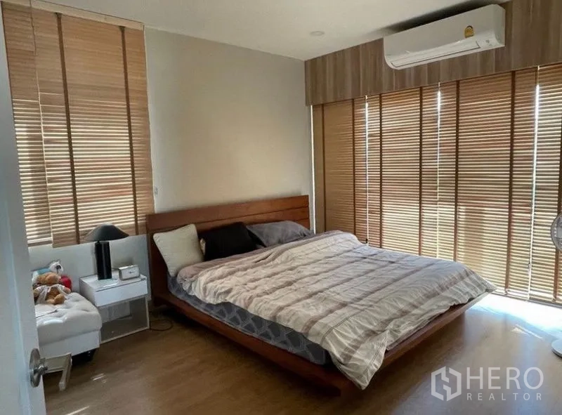 Detached House for rent - Cozy master bedroom featuring a wooden bed, wide brown blinds, and air conditioning.