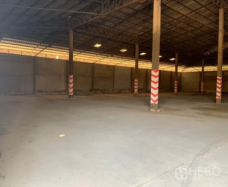 Warehouse for rent in Mueang Nakhon Pathom, Nakhon Pathom - Spacious warehouse interior with high steel‑truss roof and concrete floor.