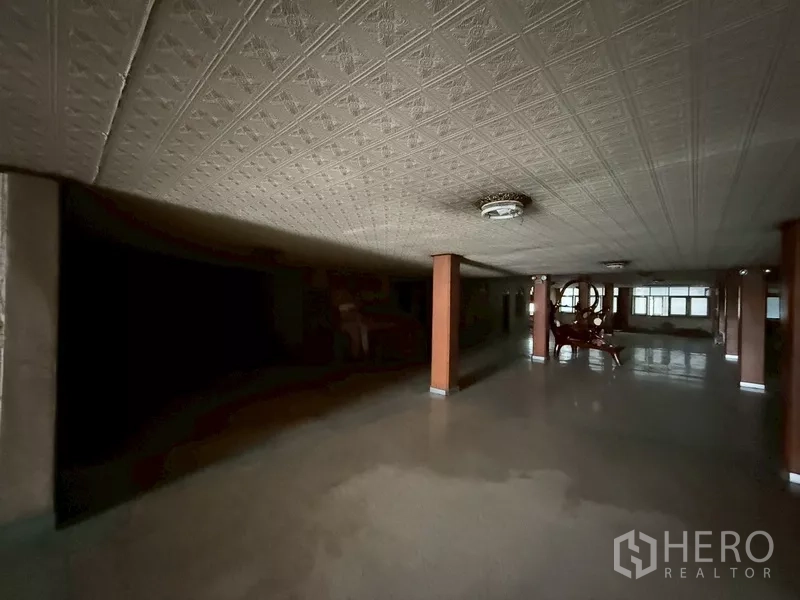 Shophouse for rent - Expansive low-ceiling hall with columns and retro light fixtures.