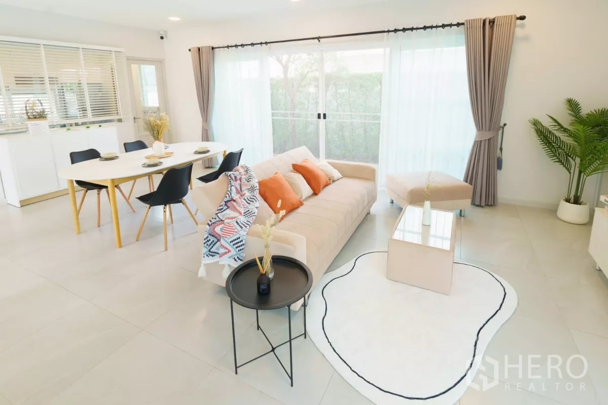 Detached House for rent in Bang Phli, Samut Prakan - Spacious living room with large windows, sheer curtains and dining set.