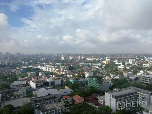 Condominium for sale - High-floor panoramic skyline view over Bangkok under a partly cloudy sky.