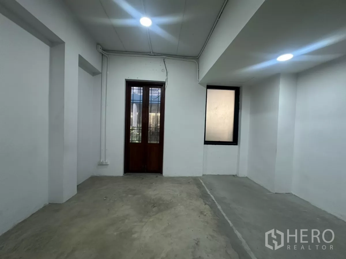 带办公室的家 出租在Pathum Wan, Bangkok - 房间配混凝土地面、白墙、木框门及侧窗。