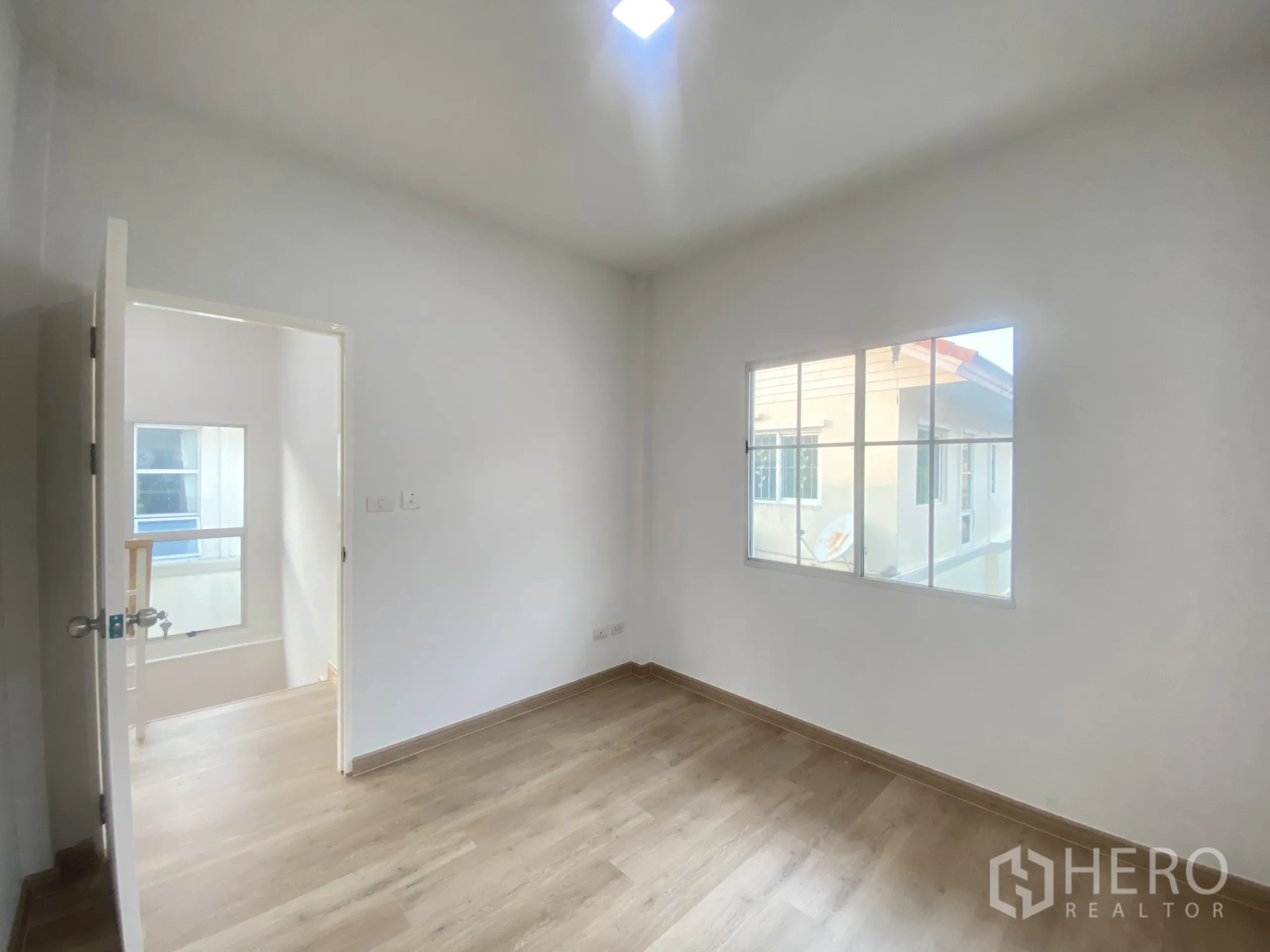 บ้าน ขายในNonthaburi - ห้องนอนที่สองมีแสงธรรมชาติและพื้นไม้ลามิเนต.