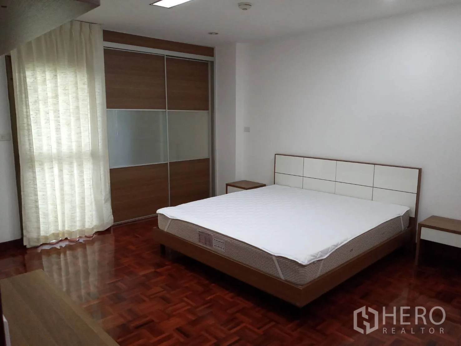 房间 出租在Watthana, Bangkok - 主卧配大床、滑门衣柜与落地窗帘。