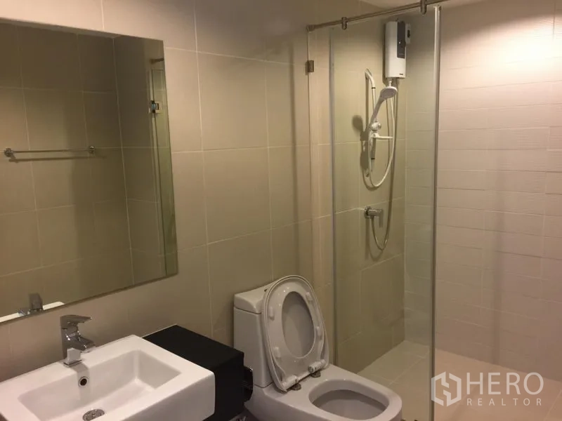 คอนโด ให้เช่าในHuai Khwang, Bangkok - ห้องน้ำสมัยใหม่ พร้อมตู้กระจกกั้นอาบน้ำ เครื่องทำน้ำอุ่น โถสุขภัณฑ์ และอ่างล้างหน้า