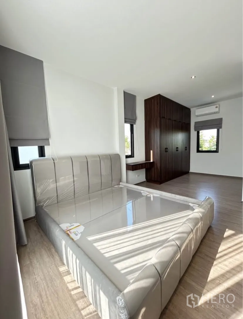 Semi-detached House for rent in Bang Phli, Samut Prakan - Spacious master bedroom with upholstered bed frame, large built-in closet and corner windows.