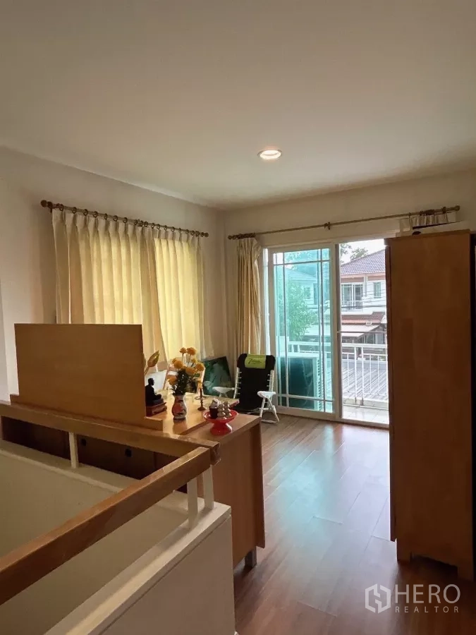 Detached House for sale in Bang Kapi, Bangkok - Bright upstairs family area with wood flooring and sliding doors to a balcony.