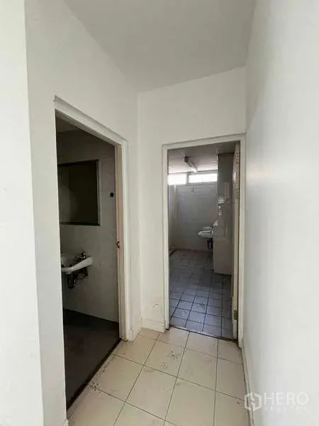 货栈 出租在Lat Krabang, Bangkok - 通往卫生间的过道，地面铺砖的工业办公区。
