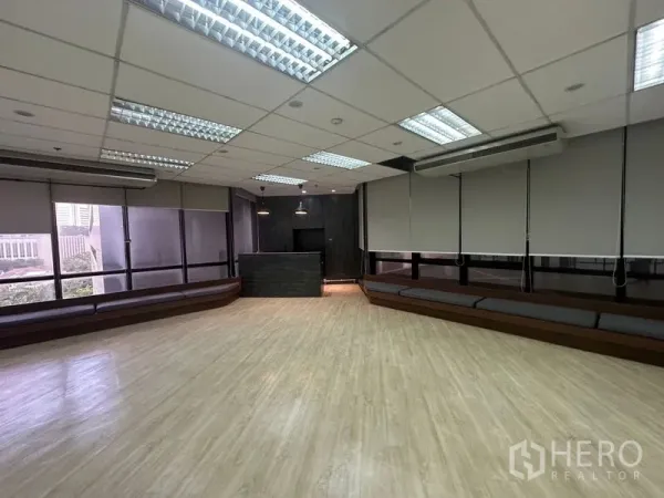 Office Space for rent in Din Daeng, Bangkok - Spacious open-plan room with wood flooring, window seating, and ceiling lights.