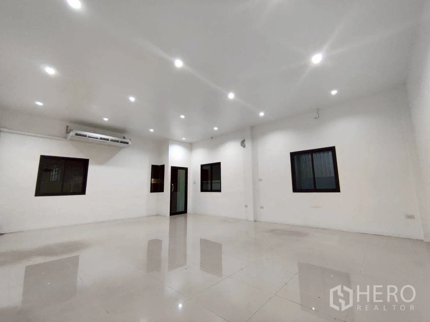 Warehouse for rent in Lam Luk Ka, Pathum Thani - Bright office room with tiled floor, recessed lights, windows, and air conditioner.