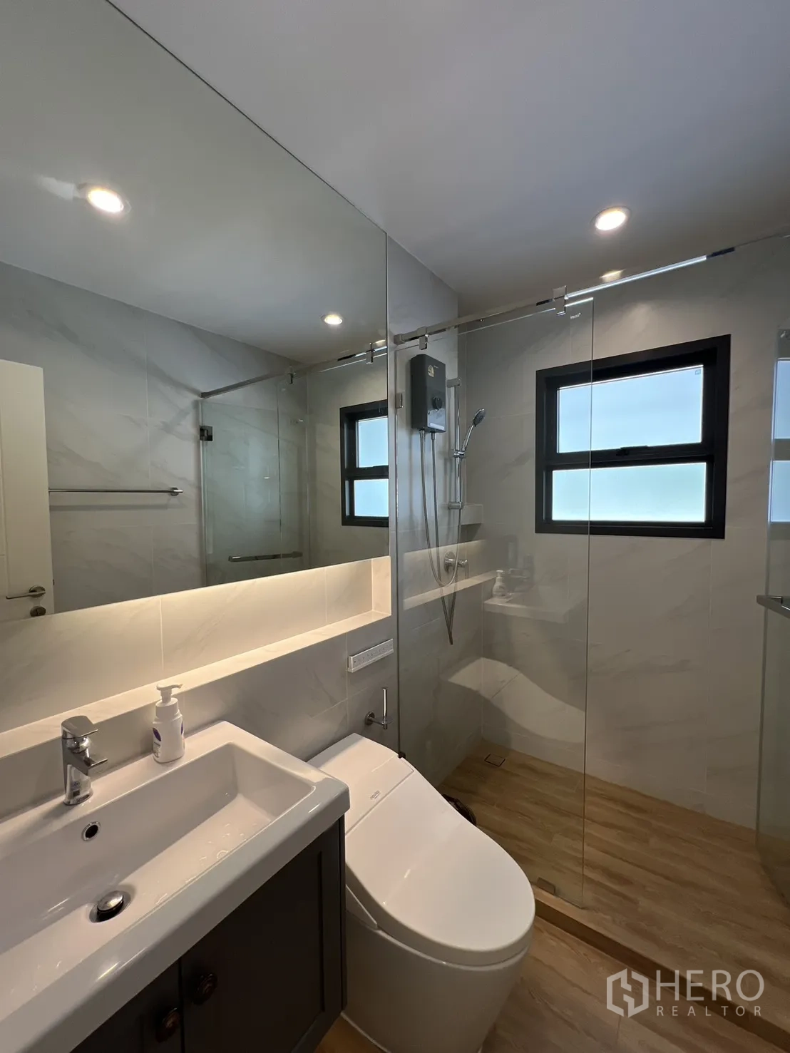 Detached House for rent in Bang Phli, Samut Prakan - Modern bathroom with glass-enclosed shower, vanity and backlit mirror.