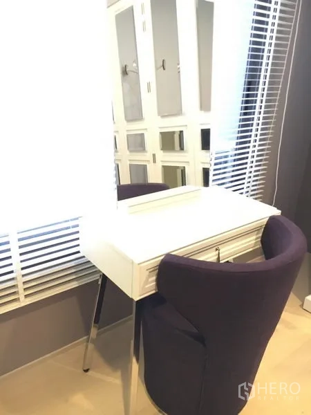 Detached House for rent in Wang Thonglang, Bangkok - Bright vanity corner with a white dressing table and purple chair by window blinds.