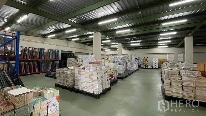 Warehouse for sale in Bangkok Yai, Bangkok - Open storage hall with concrete floor, columns and bright strip lighting.