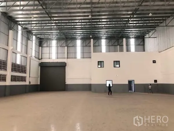 工厂 出租或出售在Samut Prakan - 仓库内景，设大型卷闸门与连接的办公区。