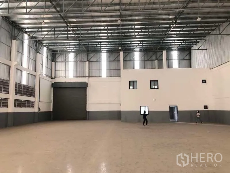 工厂 出租或出售在Samut Prakan - 仓库内景，设大型卷闸门与连接的办公区。