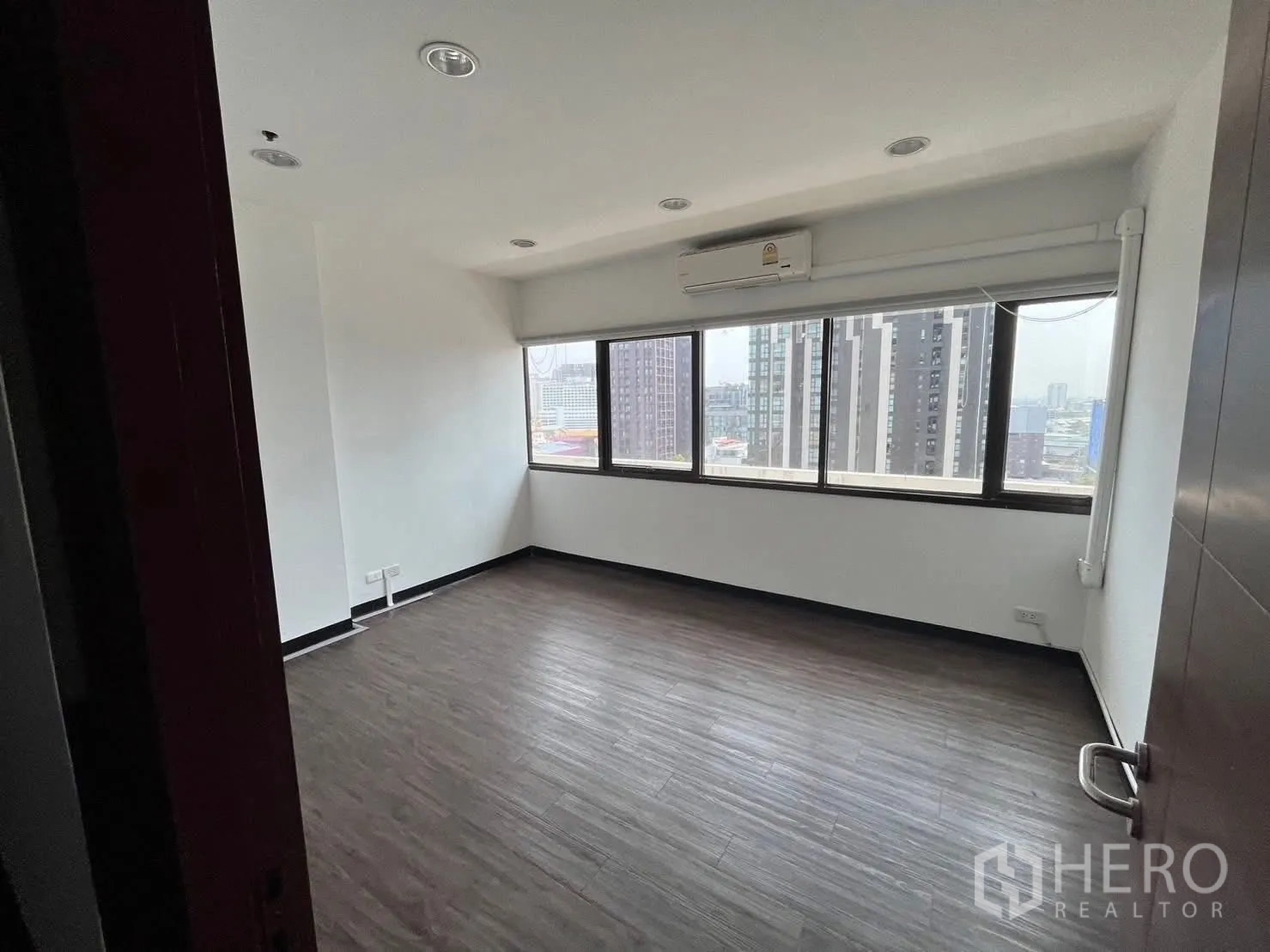 ออฟฟิศ for rent in Watthana, Bangkok - ห้องมุมสว่าง หน้าต่างยาวพร้อมมู่ลี่ มองเห็นเส้นขอบฟ้าเมือง.