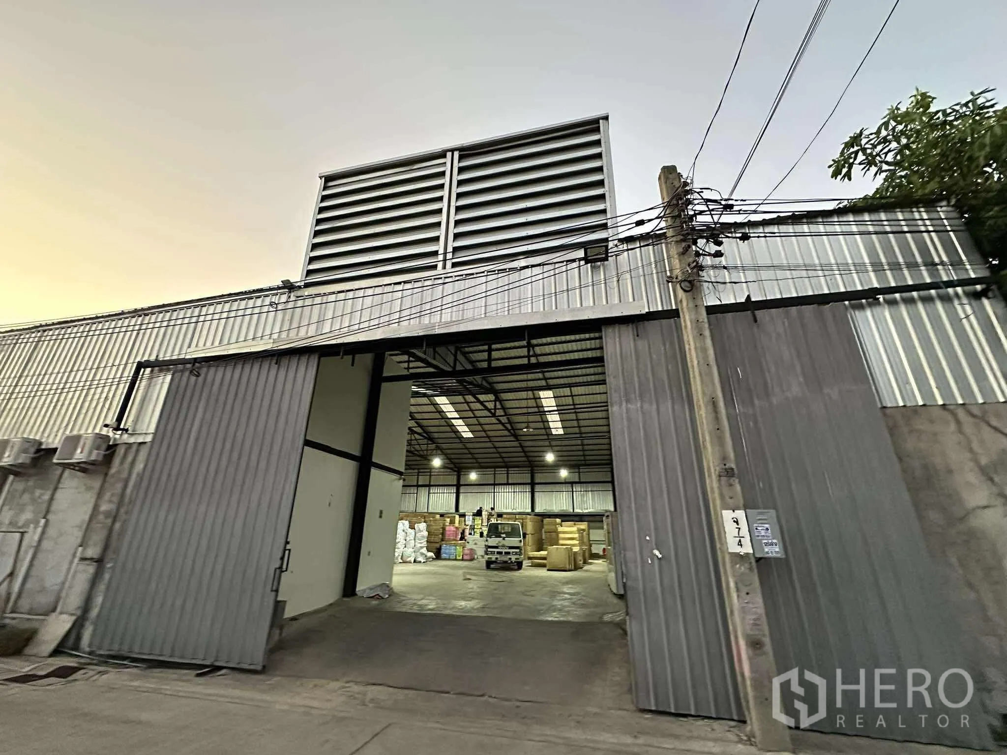 Warehouse for rent - Wide warehouse entrance with sliding doors open to a bright loading area and interior space.