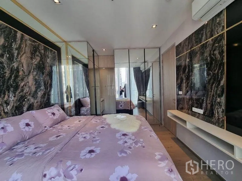 Condominium for sale - Bedroom with mirrored wardrobes, marble feature wall and timber flooring.