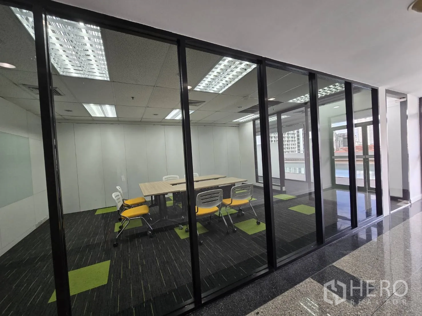 ออฟฟิศ for rent in Watthana, Bangkok - ห้องประชุมพร้อมโต๊ะและเก้าอี้สีเหลืองหลังผนังกระจก หันสู่หน้าต่างบานใหญ่.