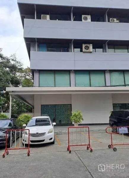 办公空间 出租在Khlong Toei, Bangkok - 曼谷多层办公楼的门前停车区与建筑立面。