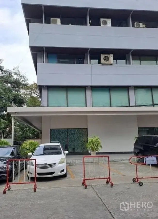 Office Space for rent in Khlong Toei, Bangkok - Front parking area and facade of a multi-storey office building in Bangkok.
