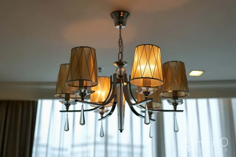 Condominium for rent in Khlong Toei, Bangkok - Modern chandelier with warm lampshades hanging from the living room ceiling.